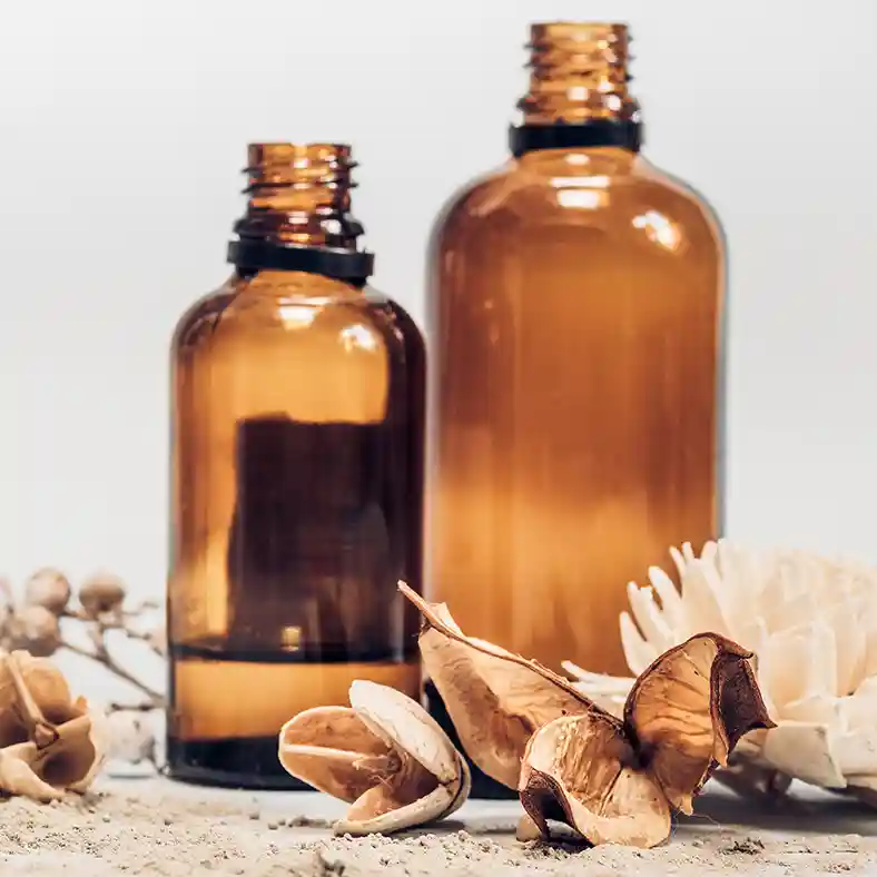 Amber glass bottles surrounded by dried flowers and pods